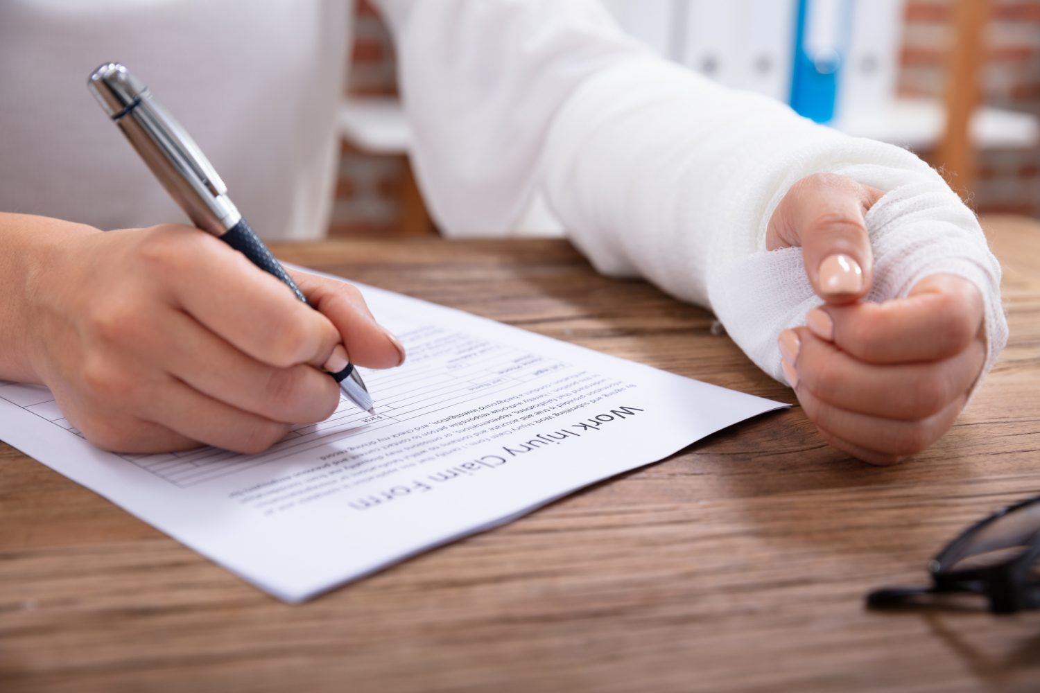 An injured worker in Boston filling out a workers’ comp claim form.