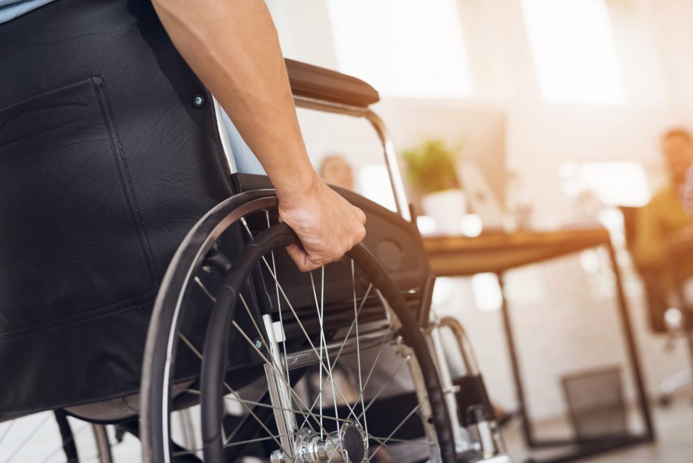 A person in a wheelchair at an appointment in an office.