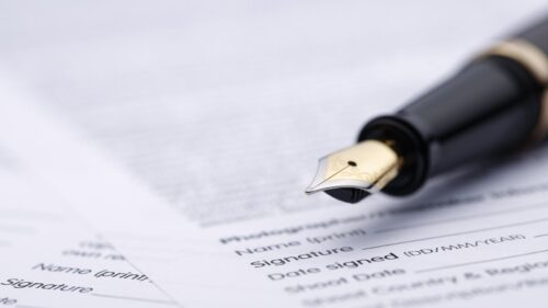 a fountain pen on a stack of contract forms