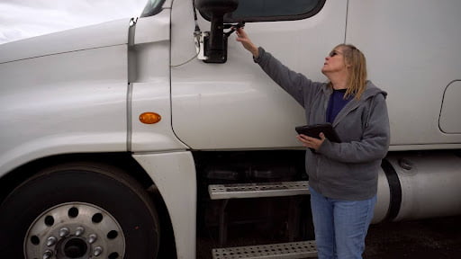 A Massachusetts truck driver inspects her vehicle before she begins driving.