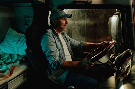A tired Massachusetts truck driver is seen driving late into the night, possibly approaching an Hours of Service violation.
