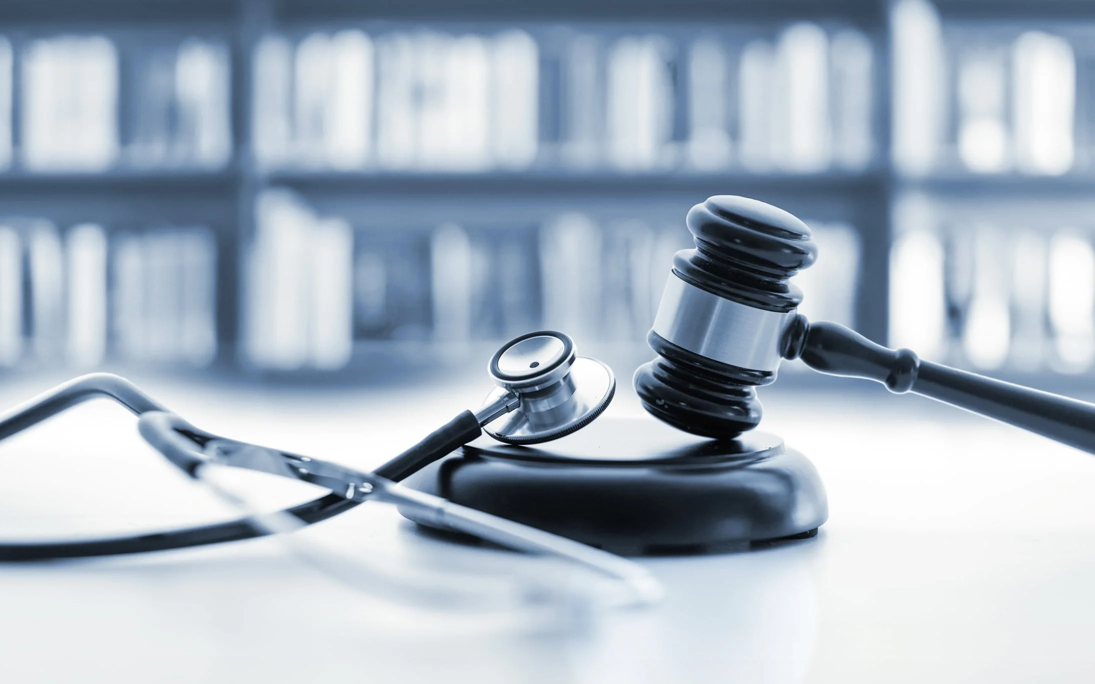 A stethoscope and a gavel resting on a sound block.
