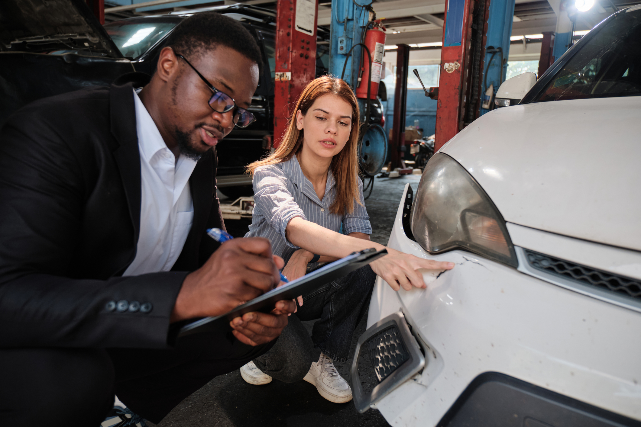 Attorney and car accident victim review the damages to the driver’s car for a car accident lawsuit.