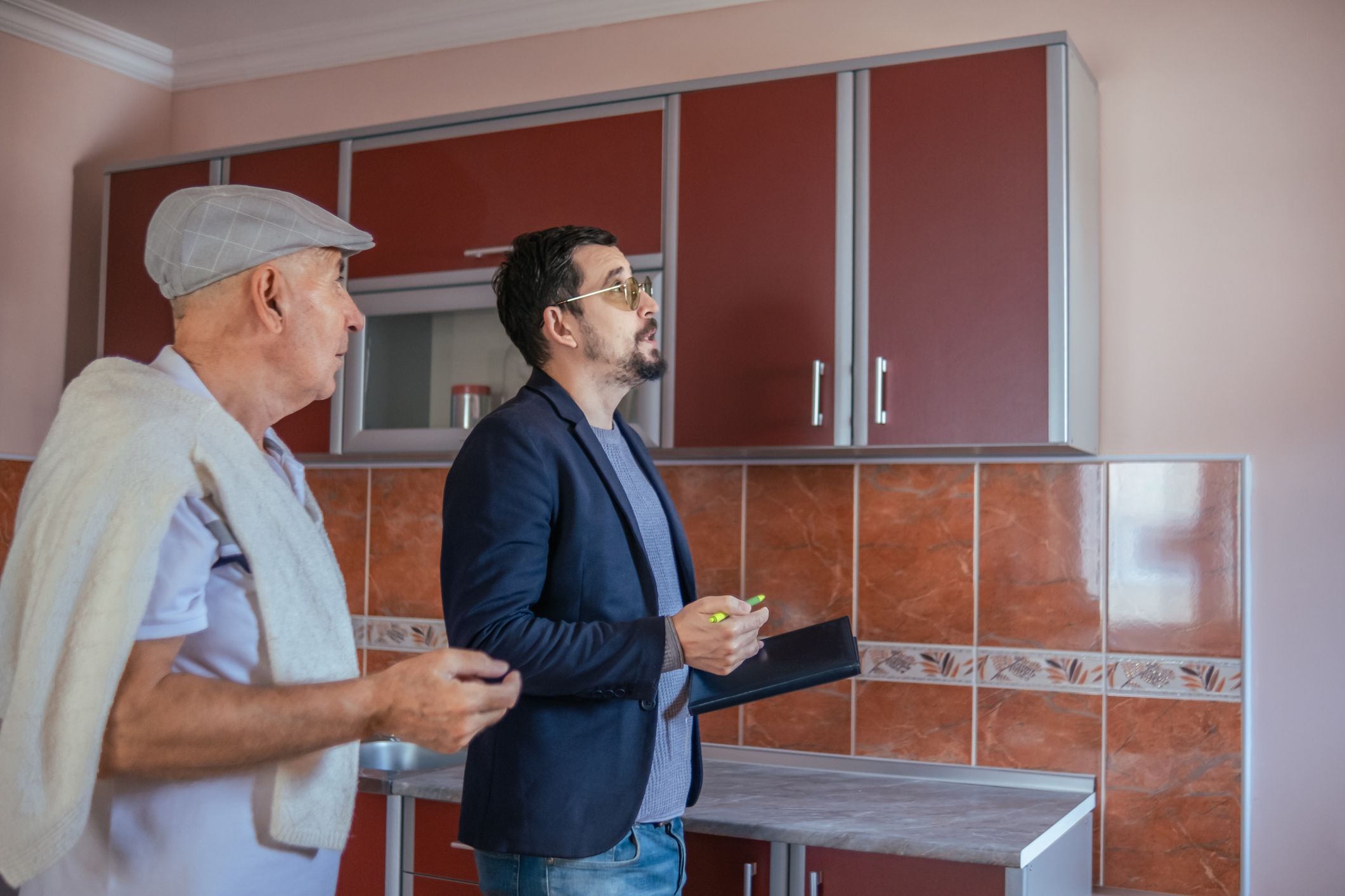 A homeowner with an insurance adjuster who is assessing damage to the property.