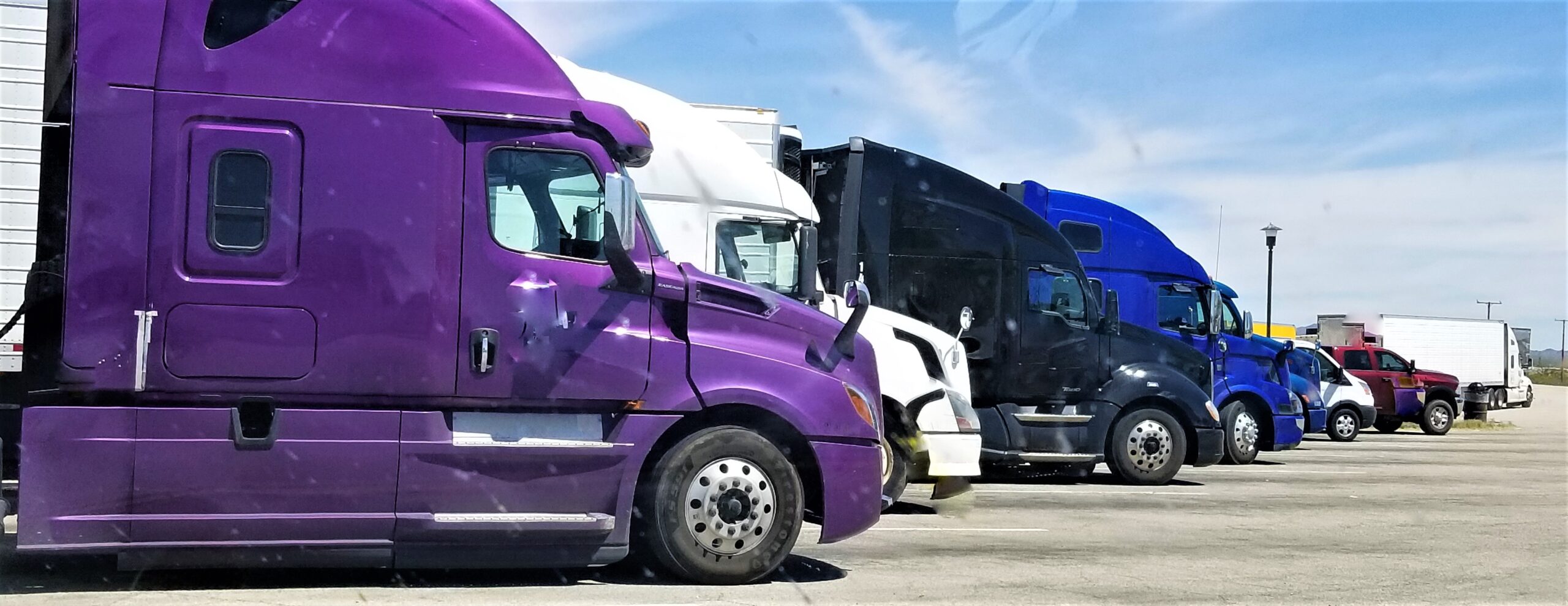 A line of tractor-trailers at a truck stop.